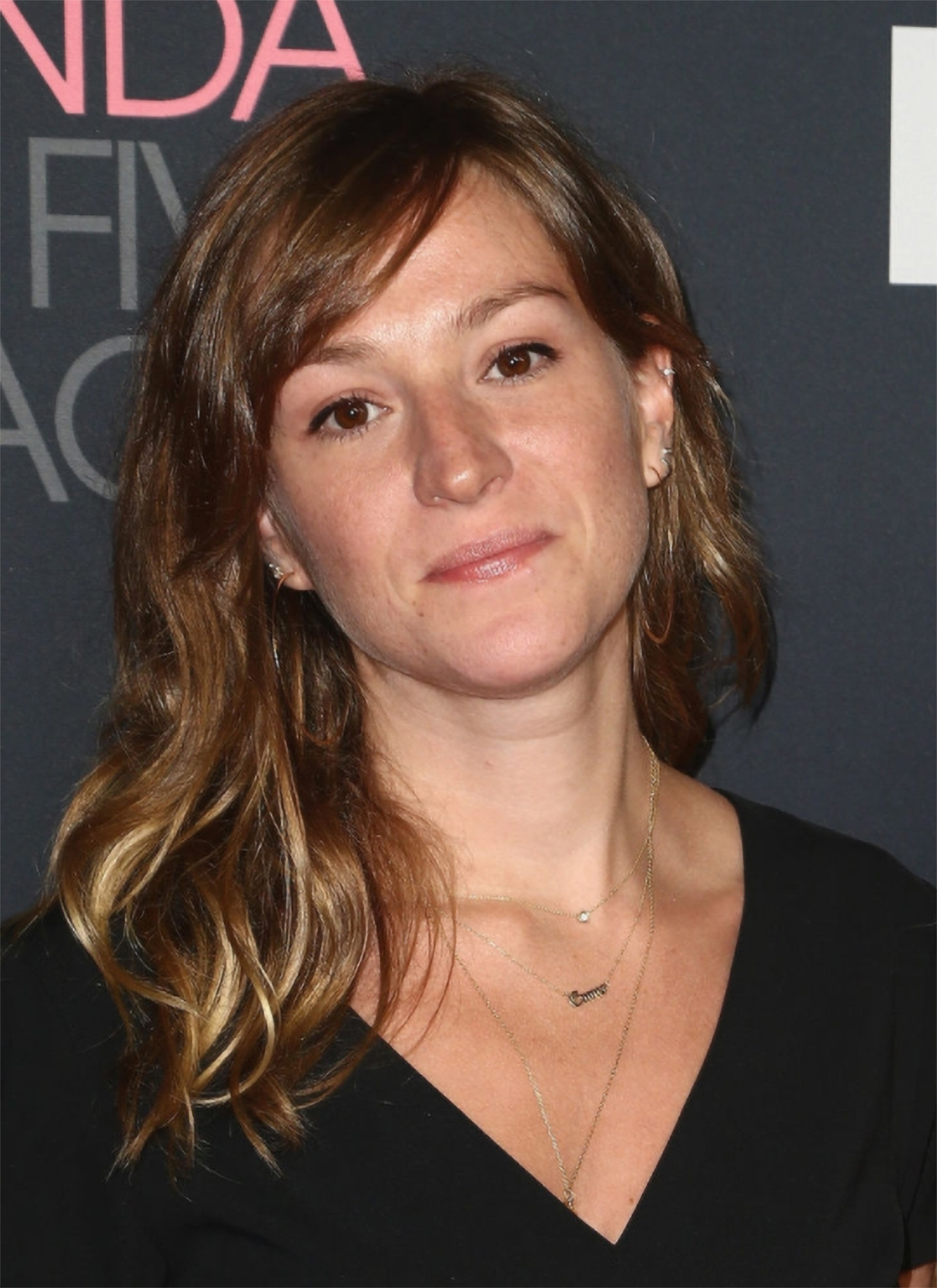 White woman with shoulder length brown hair and a black top