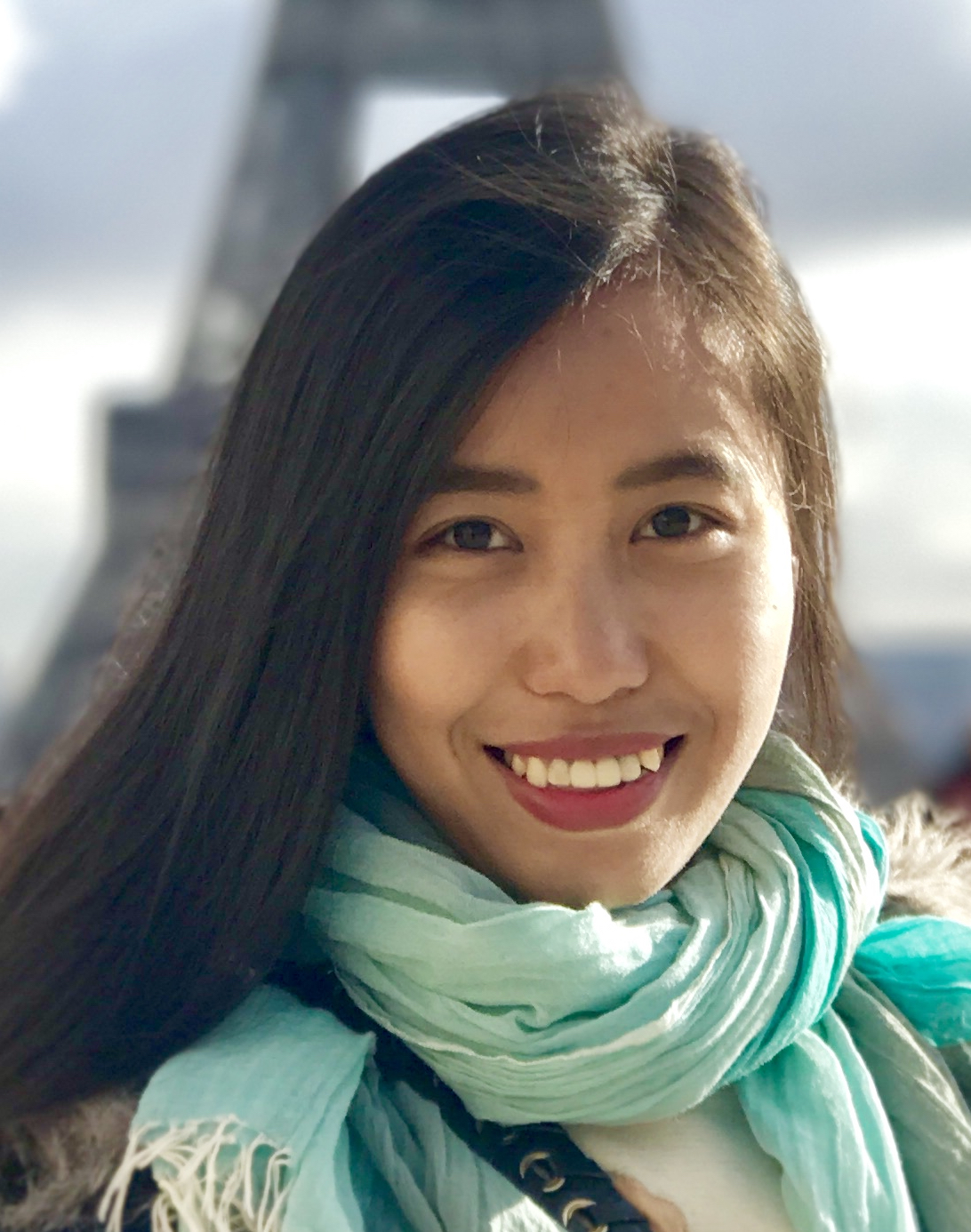 Woman with long dark hair wearing a green scarf