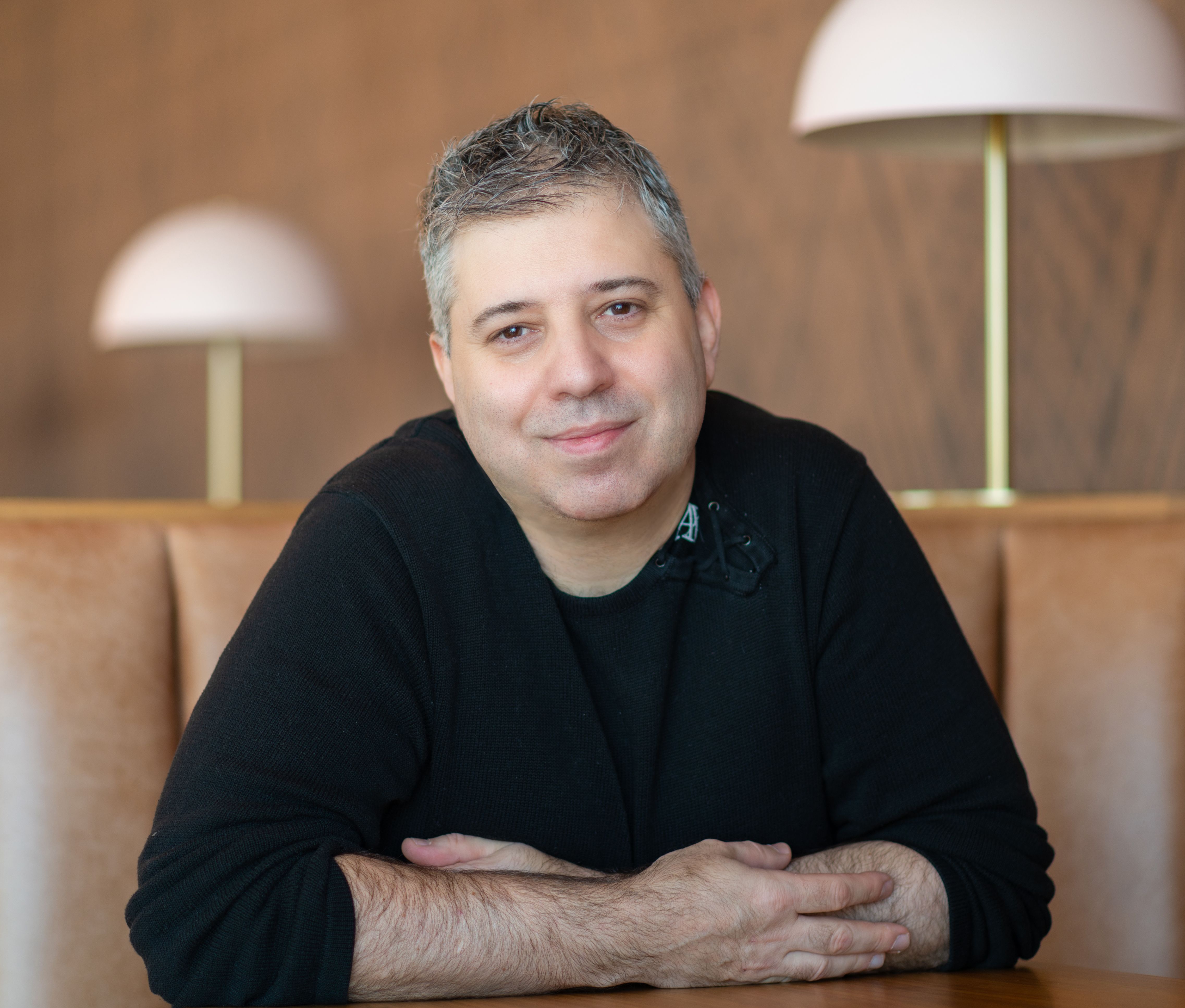 Director sitting, facing the camera with crossed arms