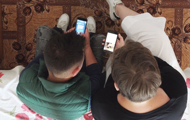 Ariel view of two people sitting and looking at their phones