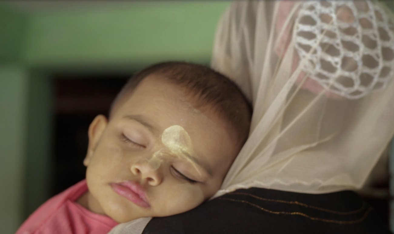 Image of a baby's sleeping face on a woman's shoulder