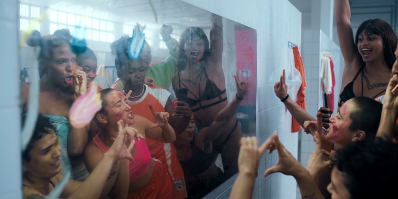 a group of friends hang out in front of a mirror, striking poses