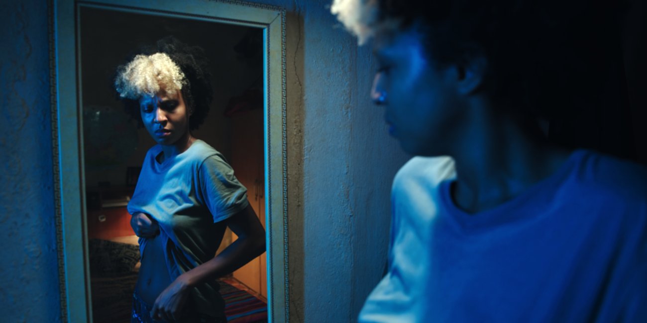 a girl examines her stomach in the mirror