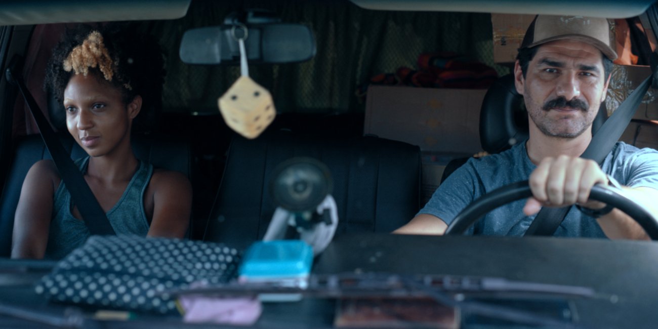 a girl is in the car with her dad, the photograph is shot from the windscreen