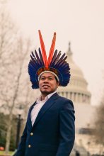 Photo of director Edivan Guajajara wearing a suit and traditional headpiece.